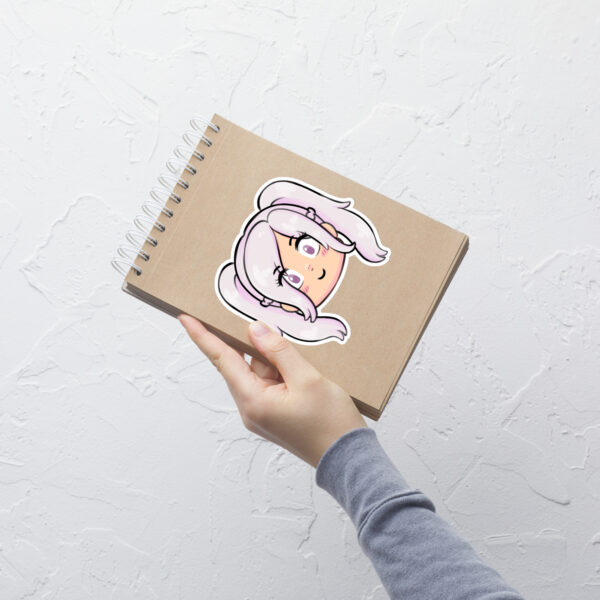 Fire Emblem sticker of Female Robin (large, 5.5x5.5) displayed prominently on a spiral notebook held upright.