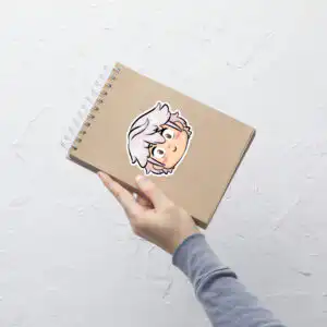 Fire Emblem sticker of Male Robin (large, 5.5x5.5) placed on a spiral notebook, highlighting size and detail.