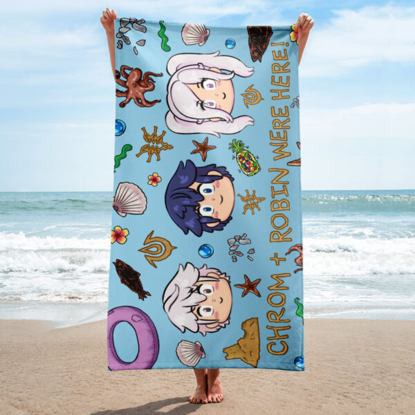 Person holding a Fire Emblem Towel on the beach, featuring the Summer Scramble (Ocean) design with chibi Chrom and Robin on a blue aquatic background.