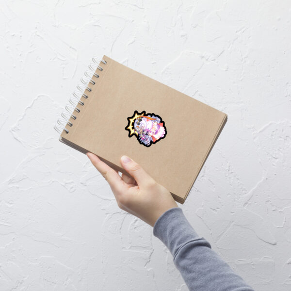 Small Fire Emblem Sticker of Vali and Baldur on a spiral notebook, shown held in hand.