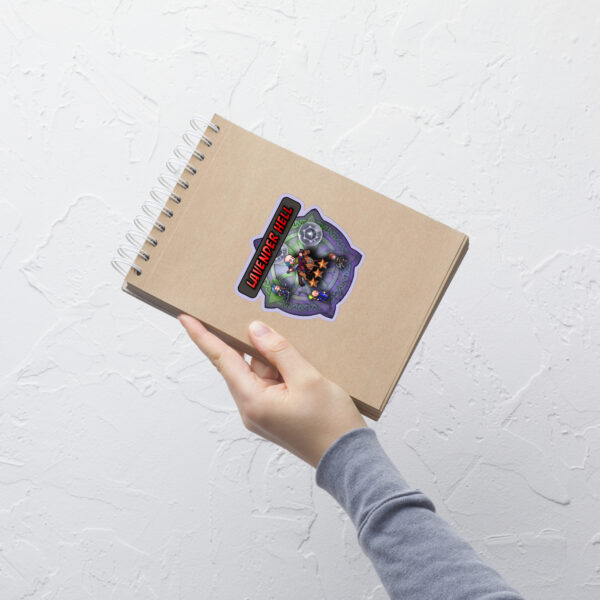 Hand holding a notebook decorated with the medium sized Lavender Hell Sticker — a parody Fire Emblem Sticker with a distressed summoning theme.