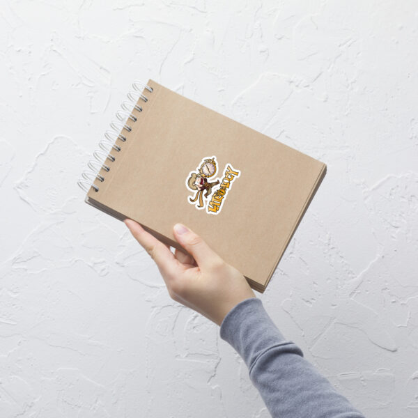 FEHology Sticker applied to a notebook with Joel chibi running and bold Lateology text