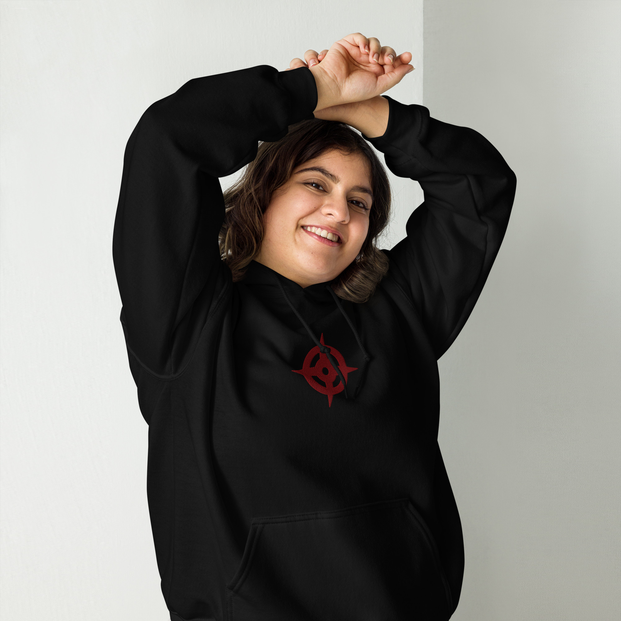 Hoshido - Unisex Embroidered Hoodie Fire Emblem Hoodie featuring the emblem of hoshido on a black hoodie, modeled by a woman smiling with arms raised.