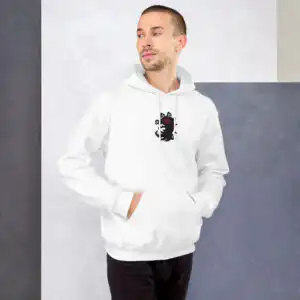 A man wearing the white Fire Emblem Hoodie from Fire Emblem Shadows against a gray wall background.